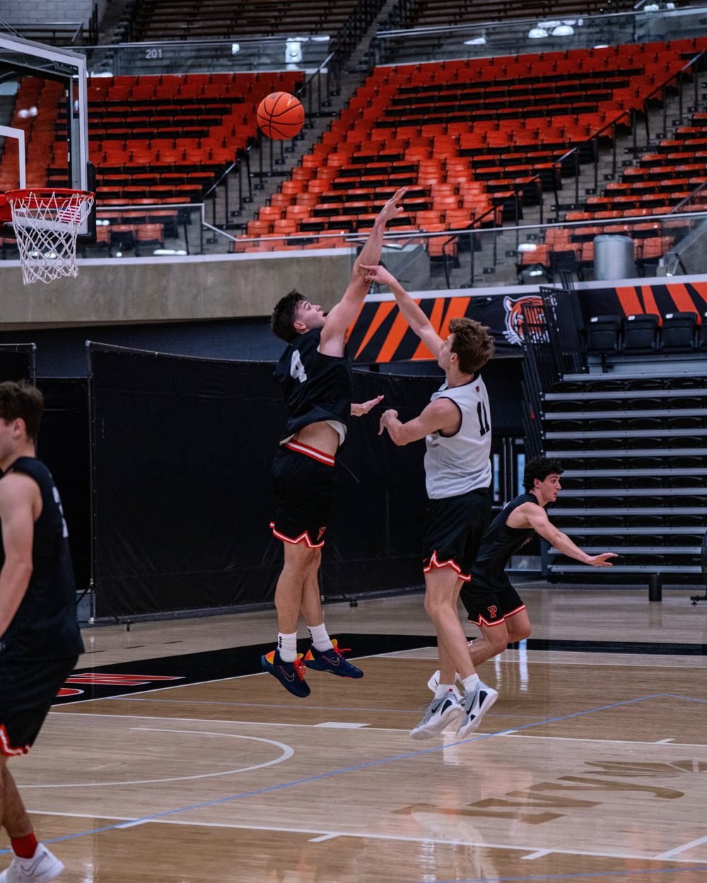 Two players leap to contest a shot at the rim in practice