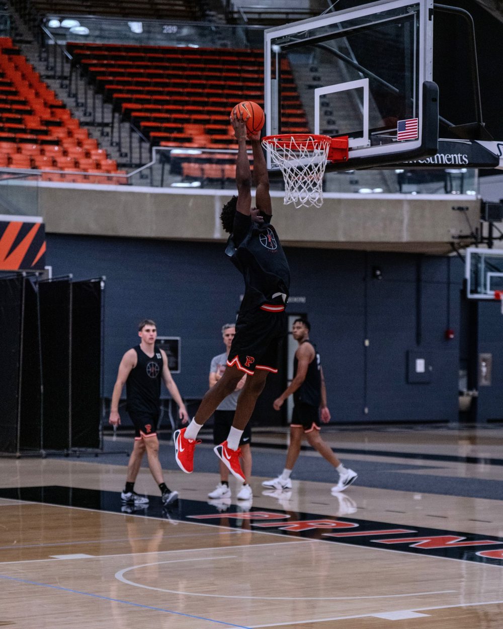 A player rises for a dunk while teammates watch